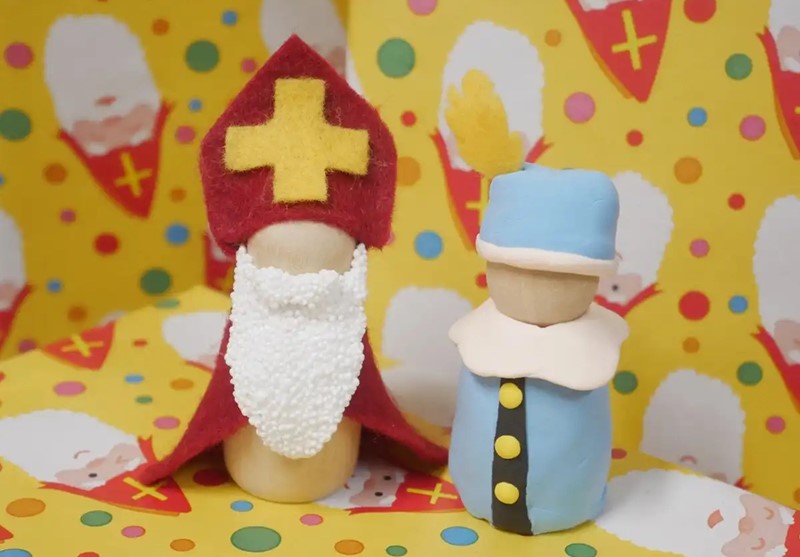 Sinterklaas en Pietje maken van houten poppetjes